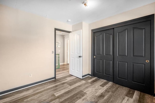 unfurnished bedroom with a closet and hardwood / wood-style floors