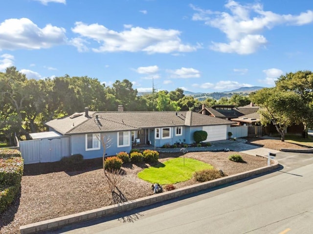 ranch-style home with a garage and a mountain view