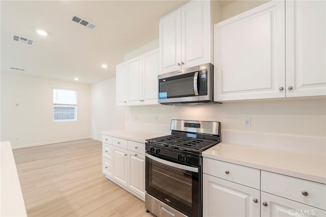 kitchen featuring light hardwood / wood-style floors, stainless steel appliances, and white cabinetry