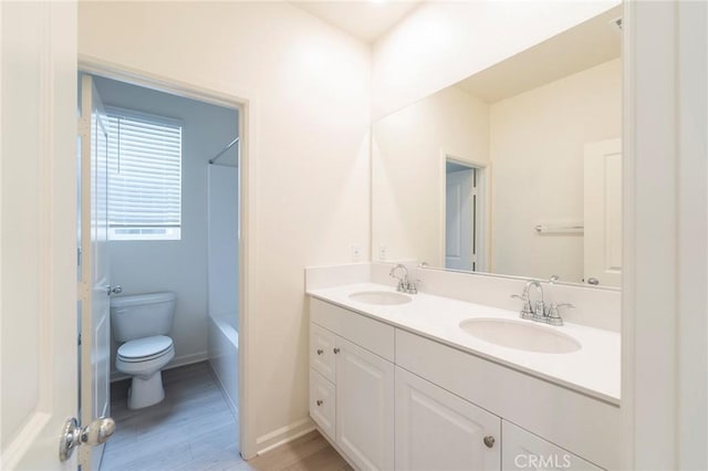 full bathroom featuring hardwood / wood-style floors, toilet, vanity, and shower / tub combination