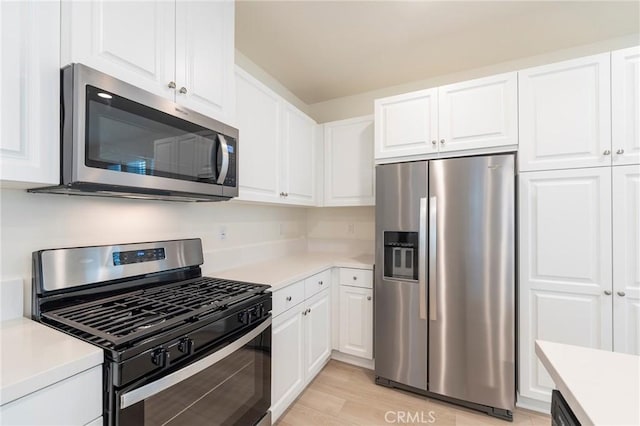 kitchen featuring white cabinets, stainless steel appliances, and light hardwood / wood-style flooring