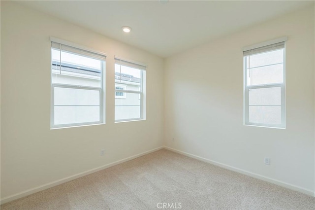 unfurnished room featuring light carpet