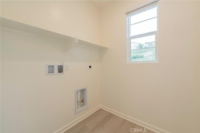 clothes washing area featuring washer hookup, light hardwood / wood-style floors, and electric dryer hookup