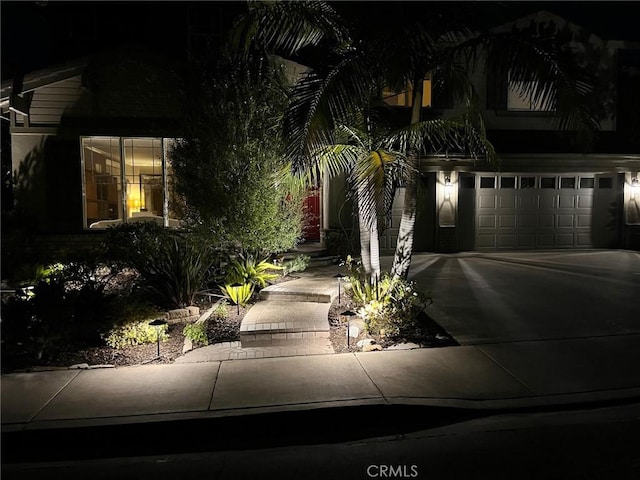 view of property hidden behind natural elements with driveway