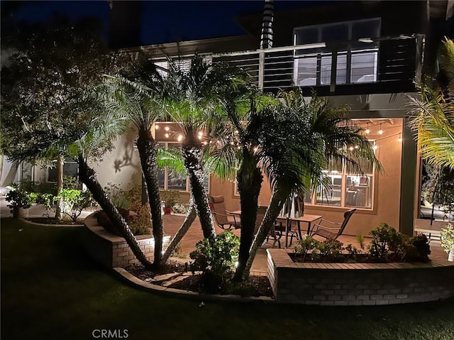 property exterior at night featuring stucco siding