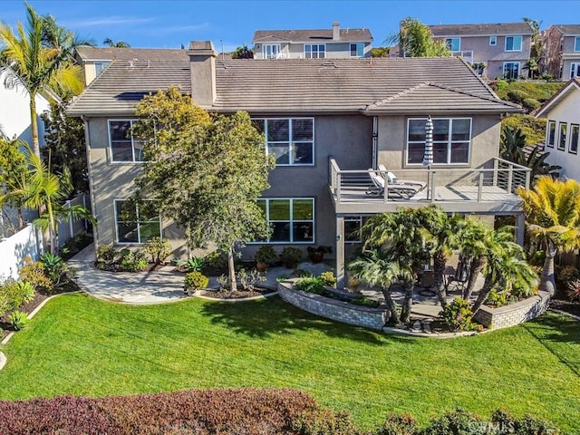 rear view of property with a yard, a patio area, and stucco siding