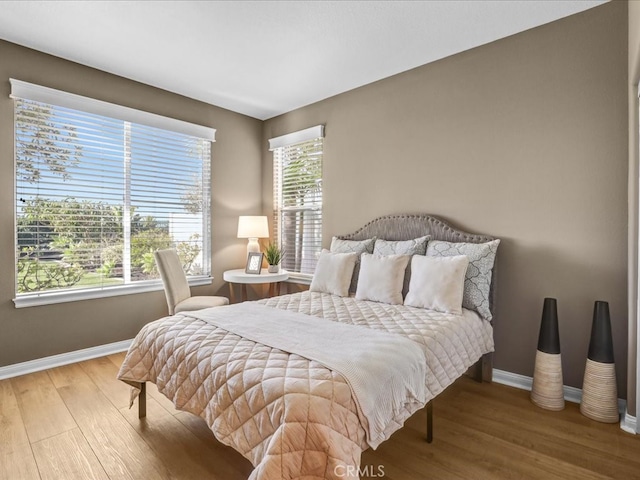 bedroom with baseboards and wood finished floors