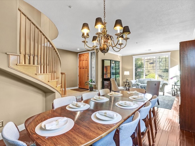 dining room featuring a chandelier, stairway, wood finished floors, and baseboards