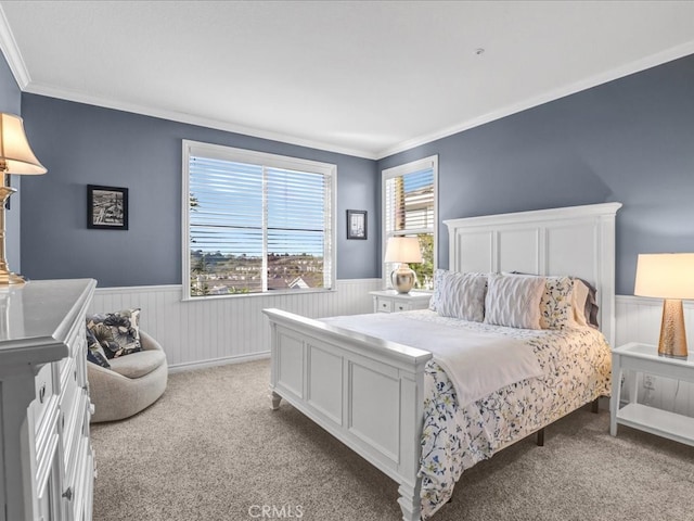 bedroom featuring light carpet, wainscoting, and crown molding