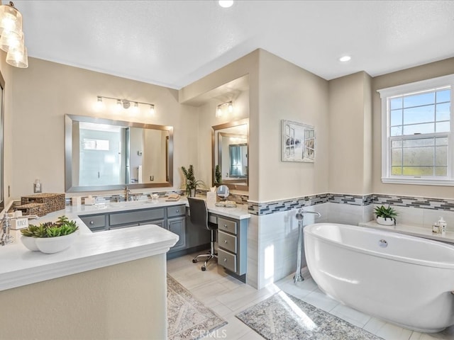 bathroom featuring a wainscoted wall, vanity, tile walls, a freestanding bath, and tile patterned floors