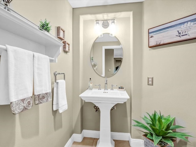 bathroom featuring baseboards, a sink, and tile patterned floors