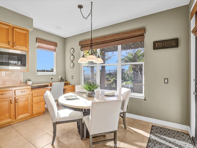 dining room with light tile patterned floors, plenty of natural light, and baseboards