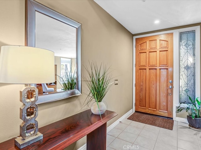 foyer featuring light tile patterned flooring and baseboards