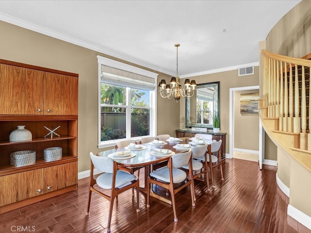 dining space with baseboards, visible vents, dark wood finished floors, crown molding, and a notable chandelier