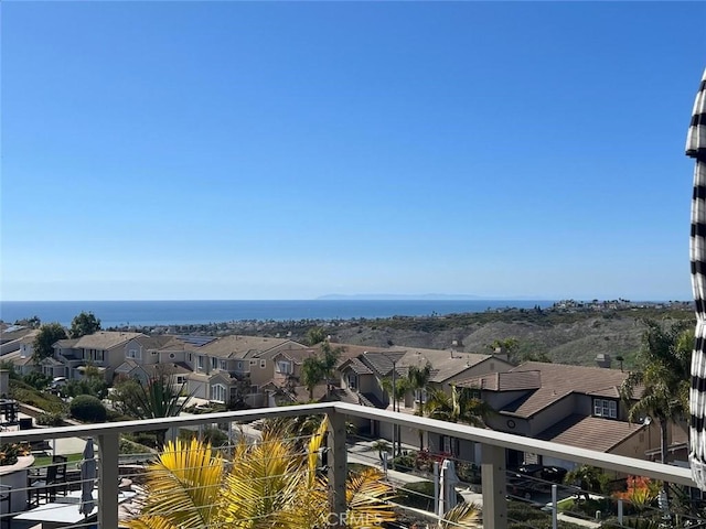 balcony featuring a residential view and a water view