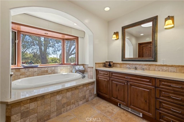 bathroom with tiled bath and vanity