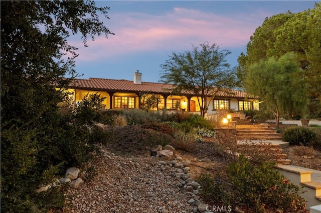 view of back house at dusk