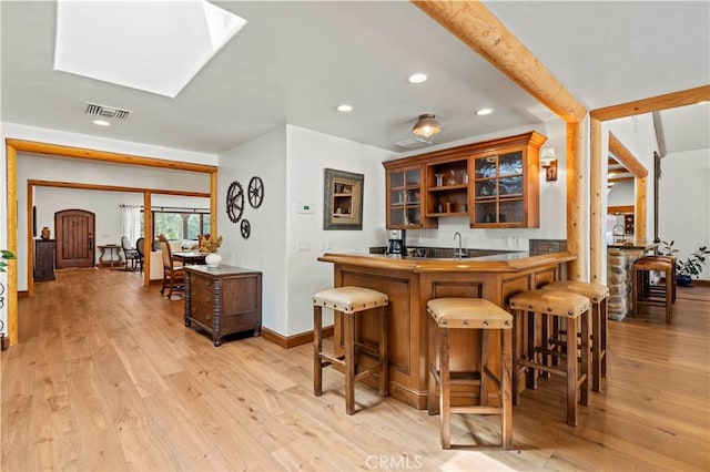 bar with light wood-type flooring and sink