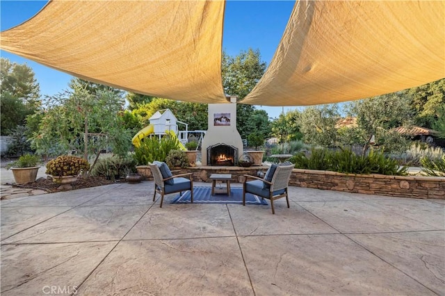 view of patio / terrace featuring an outdoor stone fireplace