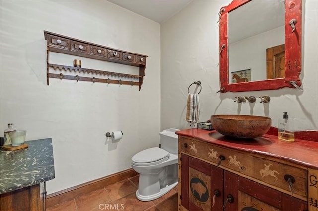 bathroom with toilet, tile patterned flooring, and vanity