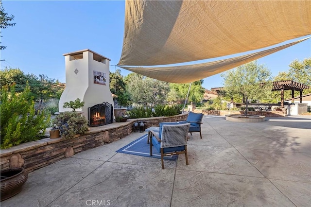 view of patio featuring an outdoor stone fireplace