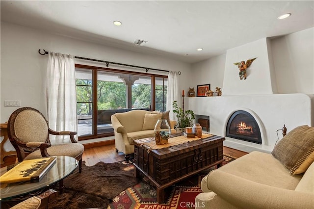 living room with a large fireplace and light hardwood / wood-style floors