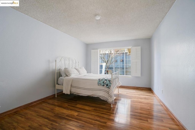 bedroom featuring a textured ceiling and hardwood / wood-style floors