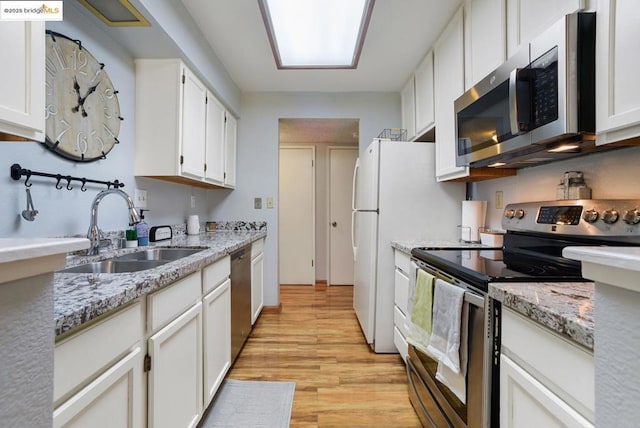 kitchen featuring stainless steel appliances, white cabinetry, and sink