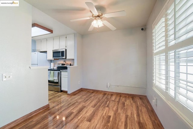 kitchen featuring appliances with stainless steel finishes, light hardwood / wood-style flooring, a healthy amount of sunlight, and white cabinetry