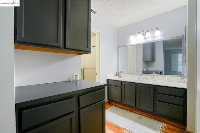 bathroom featuring vanity, a textured ceiling, and hardwood / wood-style flooring