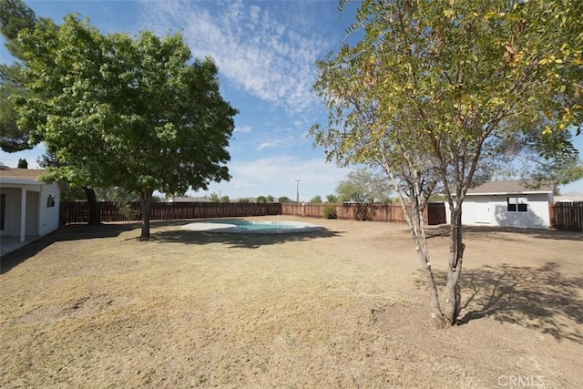 view of yard with a fenced in pool and an outdoor structure