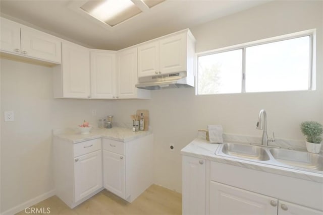 interior space with sink, white cabinets, and light hardwood / wood-style flooring