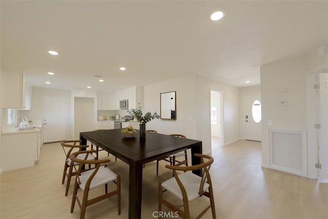 dining room featuring sink and light wood-type flooring