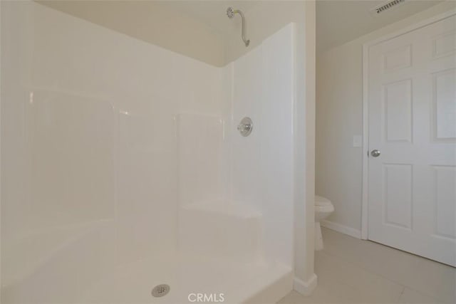 bathroom with tile patterned floors, toilet, and walk in shower