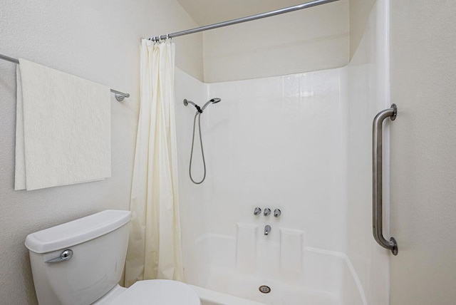 bathroom with toilet and a shower with curtain