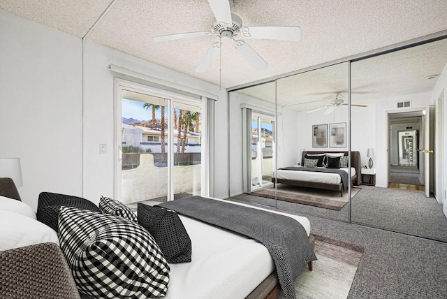 carpeted bedroom featuring ceiling fan, access to exterior, a textured ceiling, and a closet