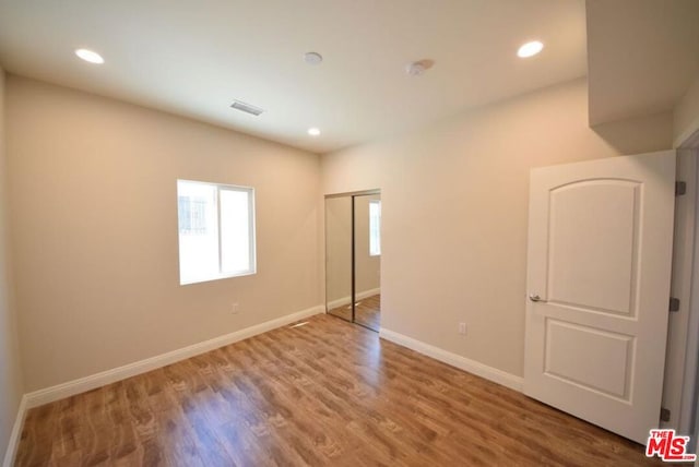 unfurnished bedroom featuring hardwood / wood-style flooring and a closet