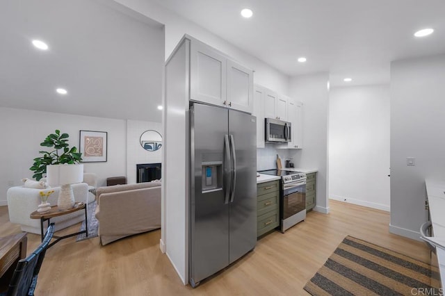 kitchen with a fireplace, light hardwood / wood-style flooring, and stainless steel appliances