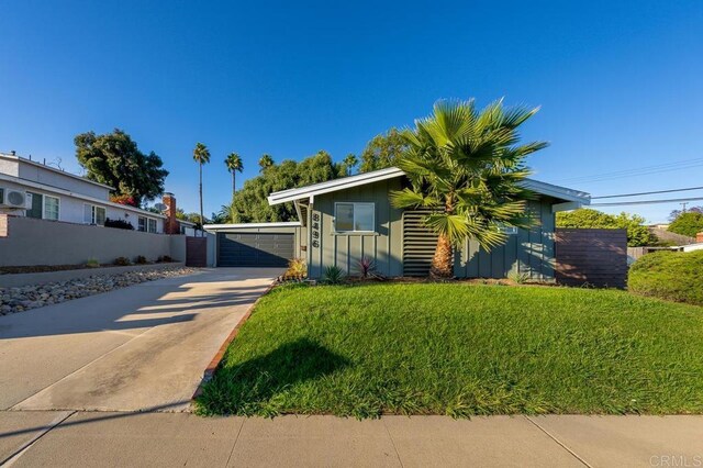 view of front of property featuring a garage, an outdoor structure, and a front yard