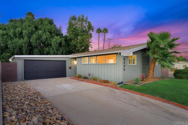 single story home featuring a yard and a garage