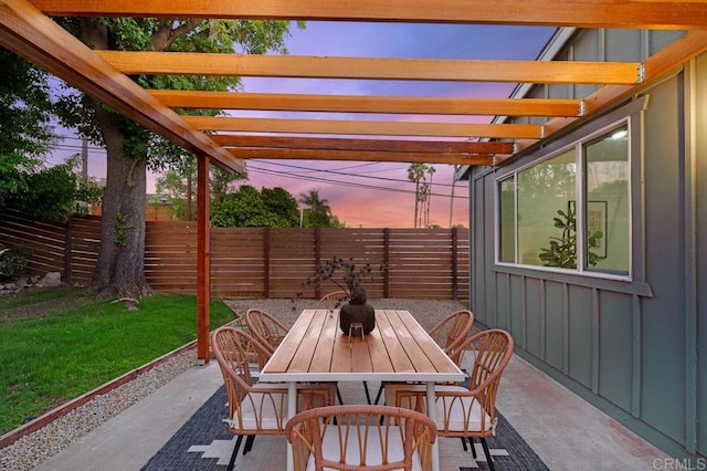 patio terrace at dusk featuring a yard and a pergola