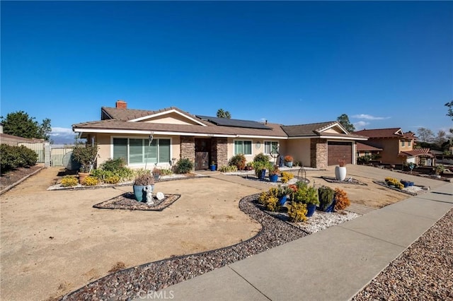 single story home featuring a garage and solar panels