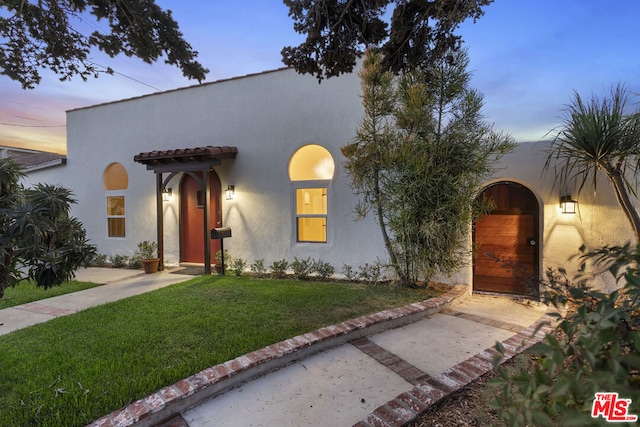 mediterranean / spanish-style home featuring a lawn