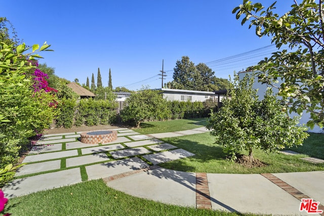 view of yard featuring an outdoor fire pit and a patio