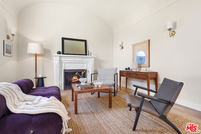 living area with vaulted ceiling and hardwood / wood-style floors