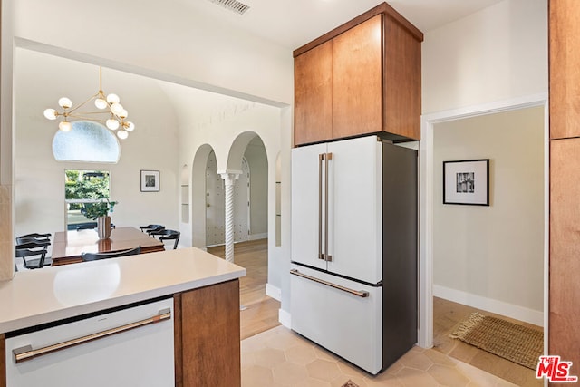 kitchen with a notable chandelier, light tile patterned floors, hanging light fixtures, and white appliances