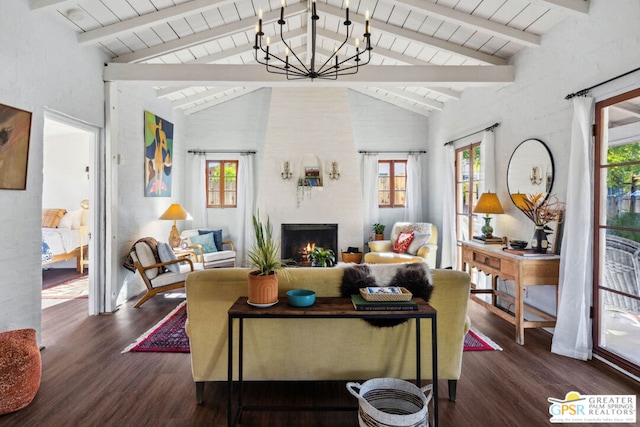 living room with beam ceiling, dark hardwood / wood-style floors, a large fireplace, and an inviting chandelier