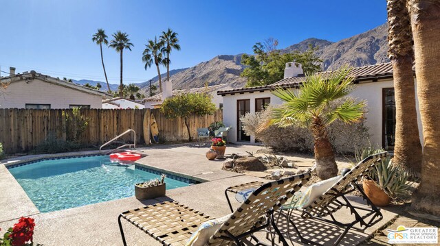 view of swimming pool featuring a mountain view and a patio area