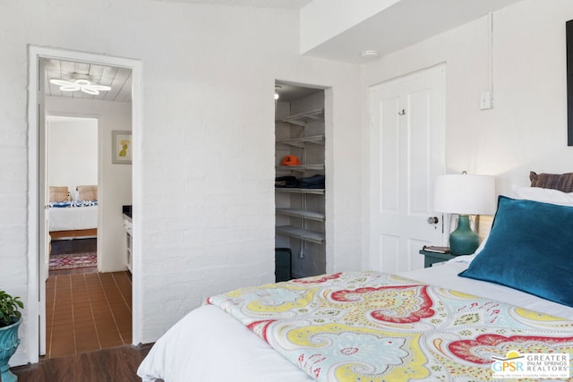 bedroom featuring a spacious closet and wood-type flooring