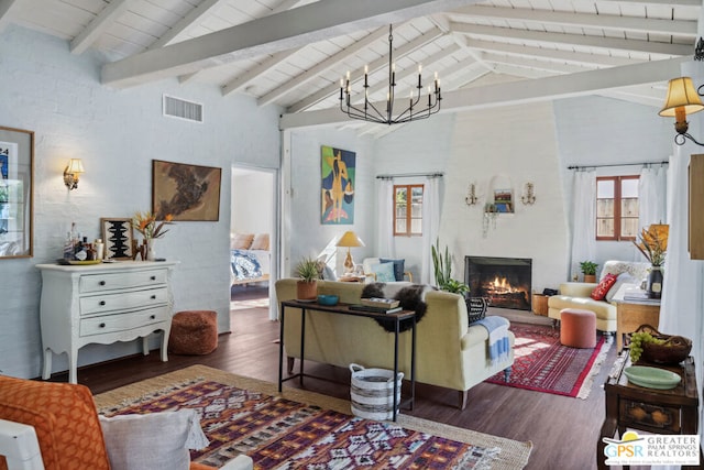 living room featuring beam ceiling, dark hardwood / wood-style flooring, a wealth of natural light, and an inviting chandelier